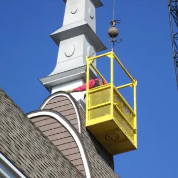 Worker in lift fixing roof